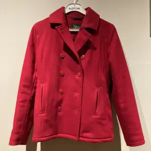 En röd fodrad jacka från peak performance i ylle. Jackan är varm och skön samt i storlek medium. Knappt använd och i ett mycket bra skick!❤️