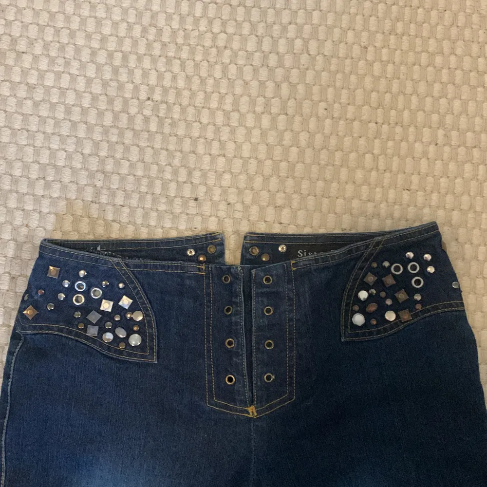 JÄTTEfina jeans med massa nitar och detaljer, bootcut/flare och låg midja som stängs med snörning. Tyvärr för små, så har inga bilder på. MÅTT: midja 79 cm, innerben 83 cm. Frakt 66 kr, dm för frågor💓. Jeans & Byxor.