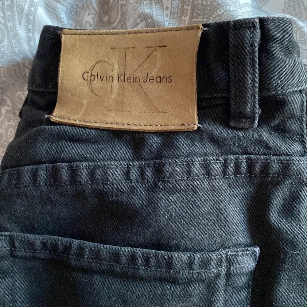 Äkta svarta vintage jeans från Calvin Klein. Mom fit, från 90-talet! Inga hål, knappen är lite lös men går att trycka fast. Gammal storleksskala som säger 8 men skulle jämföra med 26 i midjan.. Jeans & Byxor.