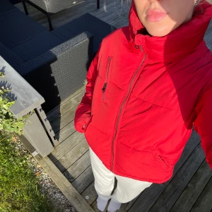 Röd NA-KD puffjacka  - Säljer denna snygga röda jacka från NA-KD då den är lite förliten för mig. Jag är 178 och skulle tipsa någon som är kortare än mig att ha den om man gillar oversized passform, annars passar den även personer i min längd Jackan säljs inte länge på hemsidan