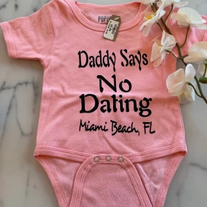 Ny lappar kvar. Body med rolig text ca 3-6 mån - Ny body med lappar kvar.  Rosa kortärmad body med roligt tryck, bedömer den till en strl 62/68 men står 18 mån på (amerikanska storlekar) 