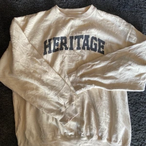 Sweatshirt  - Sweatshirt i beige färg och svart text. Vintage, bra skick men finns några fläckar på ärmarna. Därav priset. 