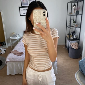 Vit/beige randig tröja från Ginatricot - Randig tröja från GinaTricot. Sitter så bra mot kroppen och är skön i materialet. Kan mötas upp eller frakta.