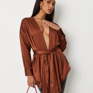 Snygg satintopp  - Säljer min fina, rostbruna satinblus pga att den blivit för stor för mig. Strl 10, motsvarar strl 38. Den är i mycket bra skick. 🤎