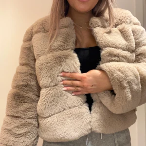 Pälsjacka  - Beige fake päls jacka från Born in Stockholm.  Onesize, passar mig som är S Liten mörk fläck på sidan av armen Betalade ca 1000kr Använt Max 5 ggr