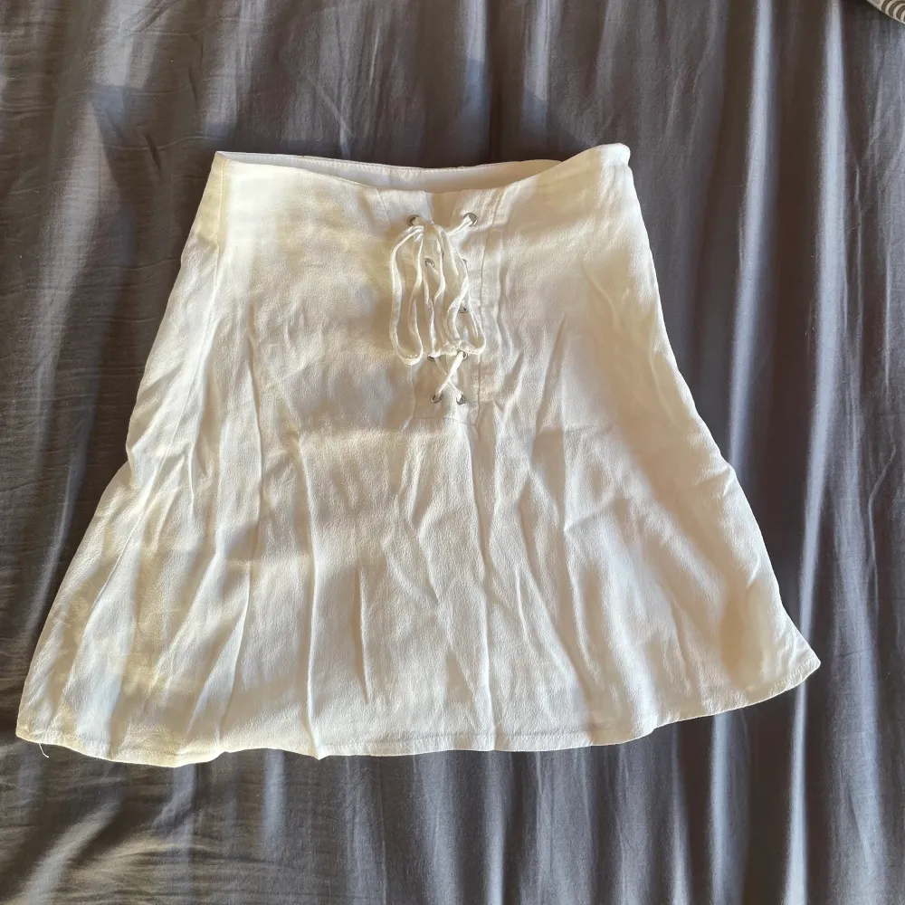 Jag säljer denna vita söta kjol som är oanvänd då jag hann växa ur den innan den kom till användning, den är i storlek 32/xs och har en dragkedja på ena sidan samt snören i mitten som är en fin detalj💕. Kjolar.