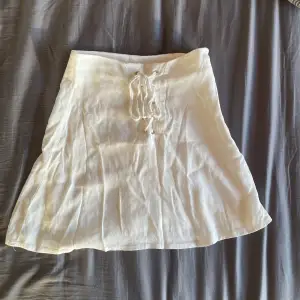 Jag säljer denna vita söta kjol som är oanvänd då jag hann växa ur den innan den kom till användning, den är i storlek 32/xs och har en dragkedja på ena sidan samt snören i mitten som är en fin detalj💕