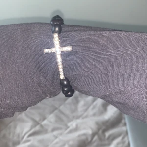 Coolt armband - Kors i diamanter och sedan svarta dödskalle pärlor runt! Knappast använt då de inte är min stil. Passar bra både till halloween och till vanliga dagar. ( 70kr + frakt)