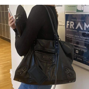 Balenciaga väska - Bra skick och köpt på vestiare collective (försäkrad äkta) för nästan 6000 kr för ett par månader sedan. Snygg till allt. Finns spegel och korthållare. Det är en gammal limited edition. Kom gärna med bud! Mått : 43 cm x 30 cm.