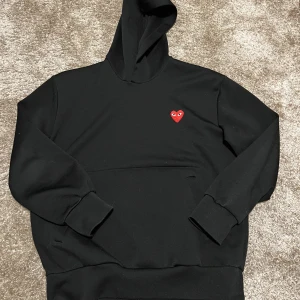 CDG PLAY heart hoodie - Comme des Garçons hoodie. Markerad med storleken XL men sitter definitivt som en M. Använts mycket men fortfarande i bra skick. Snörena saknas. Säljs då den inte kommer till användning längre. Om du har frågor är det bara att skriva.  Den är äkta. 😄