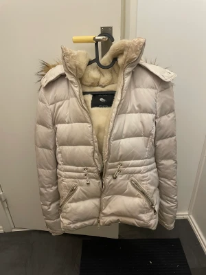 Vinterjacka - Säljer min vita vinterjacka i storlek S.  Den är varm, har en stor luva och även spännen man kan dra åt i midjan om man vill ha en bättre passform.   Kan skickas med posten eller hämtas upp i Kungsbacka, ev Lindome. 