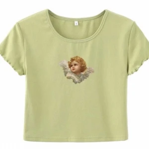 Croptop med ängel - Säljer denna jättegulliga croptop! Ser ut som på första bilden, men motivet av ängeln ser ut som på den andra. Meddela gärna om du har några frågor❤️