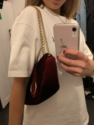 Vinröd handväska i sammet.  - Vinröd sammetväska med gulddetaljer. Känns lyxig. Använder för sällan.. ❤️ fint skick! 