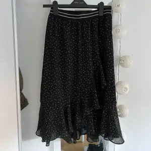 Säljer min super snygga kjol från Bondelid. Kjolen är svart med en volang och guldiga prickar. Är i nyskick och finns inga fläckar eller hål. 