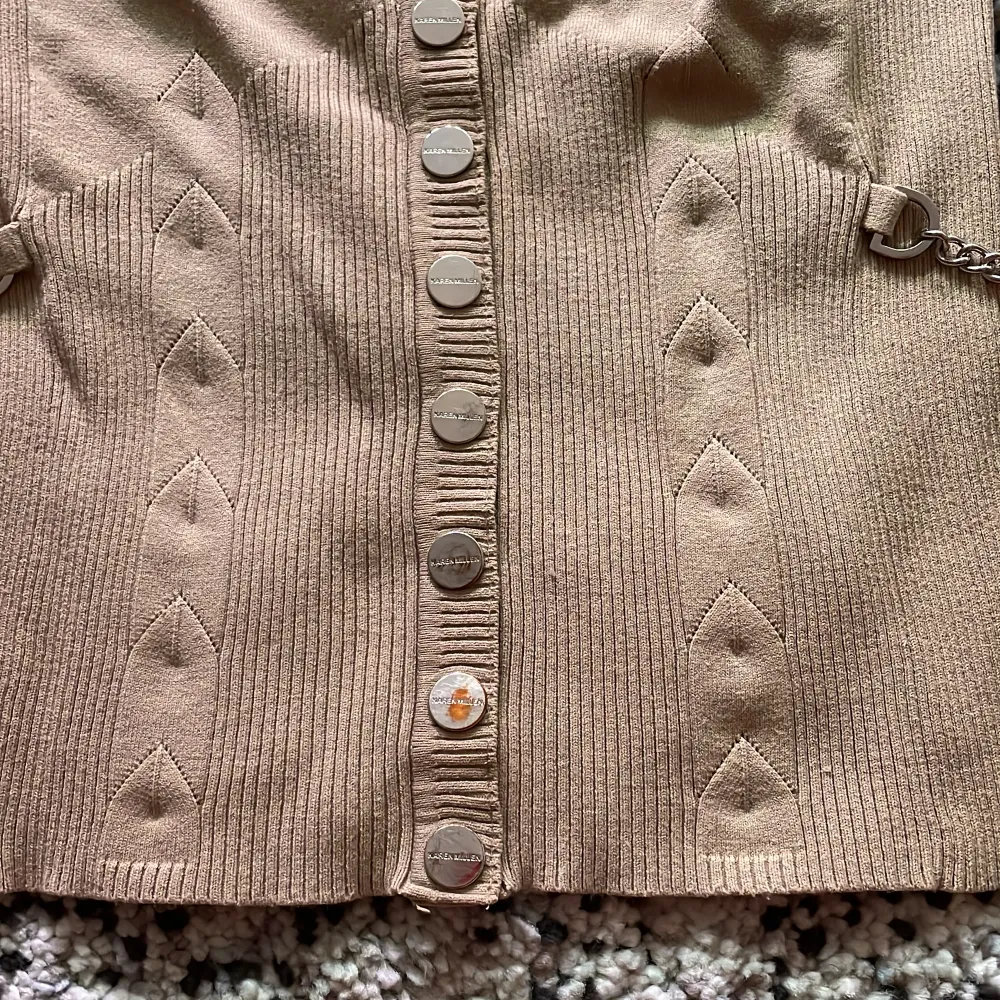 Beige cardigan.  Label size: 2, but is very small (34/xs)  Small damage on one of the buttons  Decorative silver chains on the sides . Tröjor & Koftor.