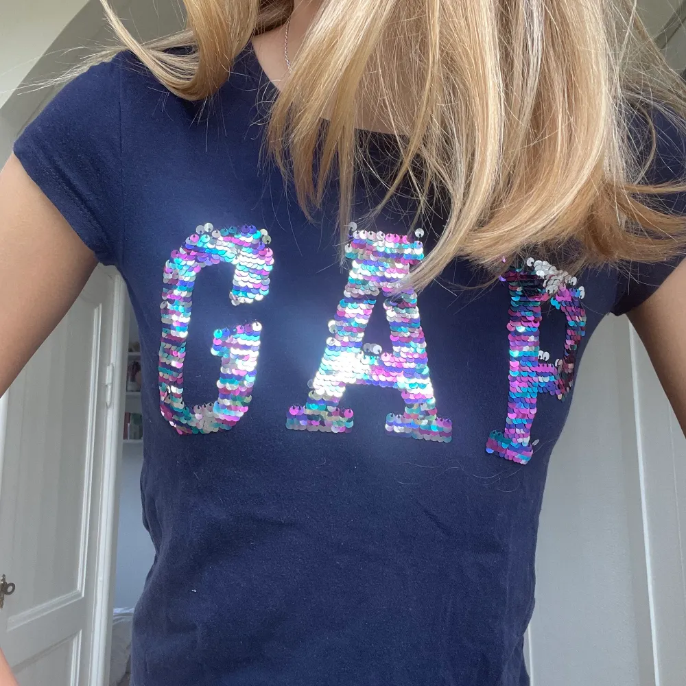 En super fin t-shirt från gap med paljetter. Den är från barn avdelningen. Står Xl men gissar att det är största barnstorleken så skulle säga att det är som en vuxen xs. Super fin att ha till vardags. Tveka inte att skriva om du vill ha flera bilder❤️. T-shirts.