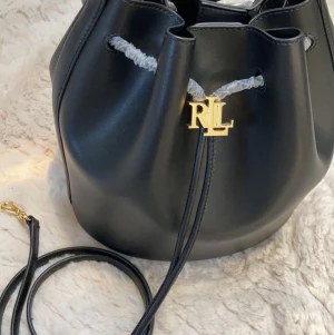 Helt ny Ralph lauren bucket bag - Säljer min helt nya Ralph lauren andie bucket bag i storlek L. Pris i butik 3795kr jag vill ha 2000kr för den, den har ff lite av plasten på så man vet att den aldrig är använd och är helt ny. Jag har fått den nyligen men det är tyvärr inte min stil :/