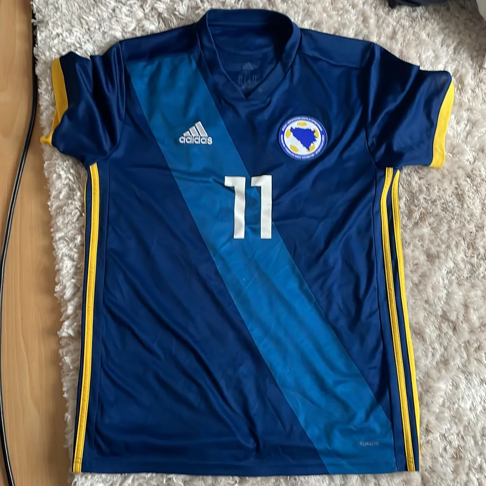 Bosnisk fotbollströja orginal med Edin Dzeko på ryggen. Tröjan är orginal och i toppskick, säljer pågrund av att jag har köpt en annan variant . T-shirts.