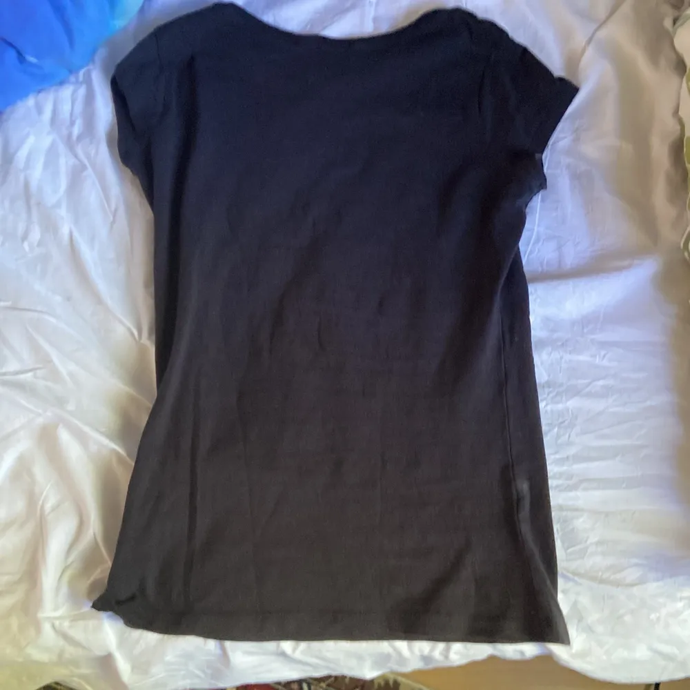 En svart tight t-shirt med smileys, gaska gammal men jag själv har inte använt den mycket men fick den av min kusin. T-shirts.