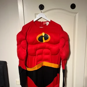 Mr. Incredible-dräkt - Säljer denna roliga Mr. Incredible-dräkt ifrån Disney-filmen Superhjältarna. Ungefär storlek M-L.  Dräkten har vadderade muskler över armar, mage och ben, ingår även en svart ögonmask i tyg. Inköpt för 799kr  