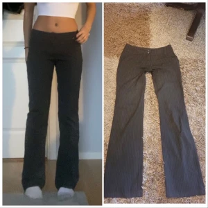 lågmidjade kostymbyxor  - Superfina mörkgråa randiga kostymbyxor som är bootcut och är lågmidjade. Midjemåttet: 76cm, Innerbenslängd: 81 cm. De har inga defekter och är som gott som nya, och de sitter även bra i längden på mig som är runt 170 cm💓