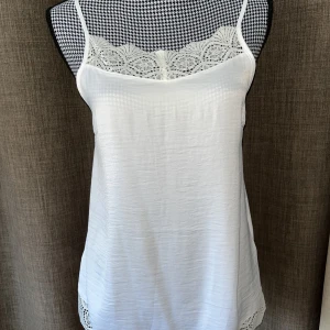 Vitt linne med spetsdetaljer stl.40 - Vitt linne i stl.40  Fina spetsdetaljer uppe vid byst och nedtill.  Jättefint skick utan några fläckar, hål eller dylikt   Samfraktar 