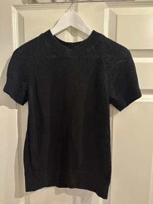 Stickad tshirt - Stickad t-shirt från Arket, svart, storlek S.