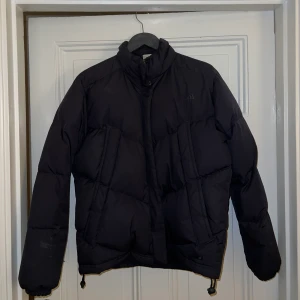 Adidas Puffer Jacket - Säljer varm mörkblå Adidas Puffer Jacket perfekt för vinterns kyla! Köptes för många år sedan endast använt fåtal gånger under vintern 2017! Uppskattar storlek M/L 