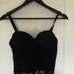 Svart partylinne "korsett"  - Svart topp som går att välja storlek på genom spännen på baksidan. Använd enstaka gång. Axelband som går att ta av och på. 