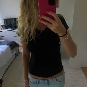 Tshirt - Svart t-shirt som jag själv gjort detaljen på. Köpt seconhand men från Northbrook. 