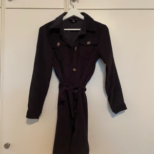 Manchesterklänning i storlek XS - Normal i storlek och i fint skick. Knappar framtill och bälte i midjan