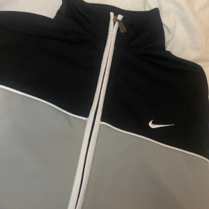 Nike kofta - Nike kofta, hel svart där bak, grå, svart, vit där framme. Kommer ej t användning.   