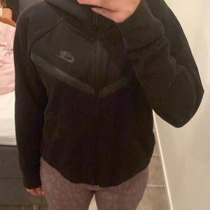 Nike Tech Fleece full zip hoodie i svart, köpt för 1099kr på JD sport, använd fåtal gånger och i fint skick. Tjejmodellen. Jätteskön och fin till vintern. 