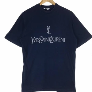 Yves Saint Laurent T-shirt - Riktigt fet Yves Saint Laurent / YSL t-shirt. Storlek Large tts, sitter ganska baggy. Bara o skicka ett meddelande om du har någon fråga, vill ha mått eller fler bilder✌🏼
