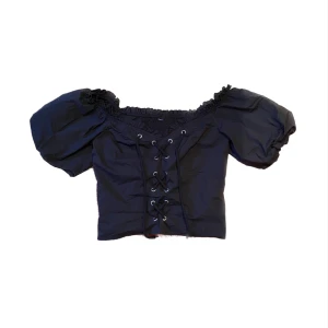 Snörad topp - Sött topp med puff ärmar och snörning fram. Den har ingen storleks märkning men skulle säga att den är i storlek S/M