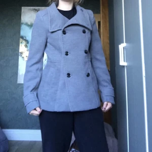 Stilig kappa - Snygg kappa perfekt för milt till kallare väder. Säljer pga att den inte kommer till användning. Det står att den är storlek 38 men den är mindre i storleken så skulle säga att den passar bättre för 36