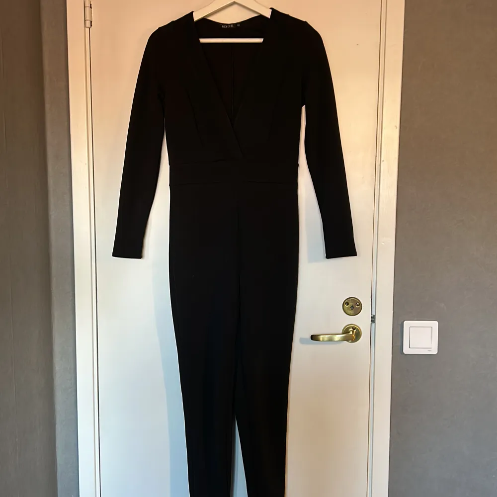 svart jumpsuit, mycket sparsamt använd. från nelly i storlek medium. ”bälte” i mitten. Klänningar.