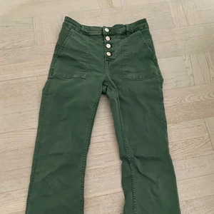 Gröna jeans zara - Ett par skitsnygga gröna jeans från Zara med hög midja och flera knappar! Jeansen är utsvänga nertill och sitter väldigt smickrande över benen. Storlek 38! Köparen står för frakten.