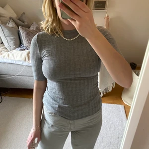 Grå kortärmad topp  - Säljer min gråa topp från Gina Tricot i storlek M. Ribbade detaljer och stretchig i tyget. Köparen står för frakten och fraktar endast.🤍