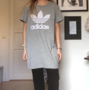 AdidasXPharell Williams T-shirt dress - T-shirt klänning från Adidas. Knappt andvända och går att använda på många sätt både som tröja eller klänning. Perfekt till sommaren!! Den är i storlek s men väldigt oversized. T-shirten är från Adidas X Pharell Williams
