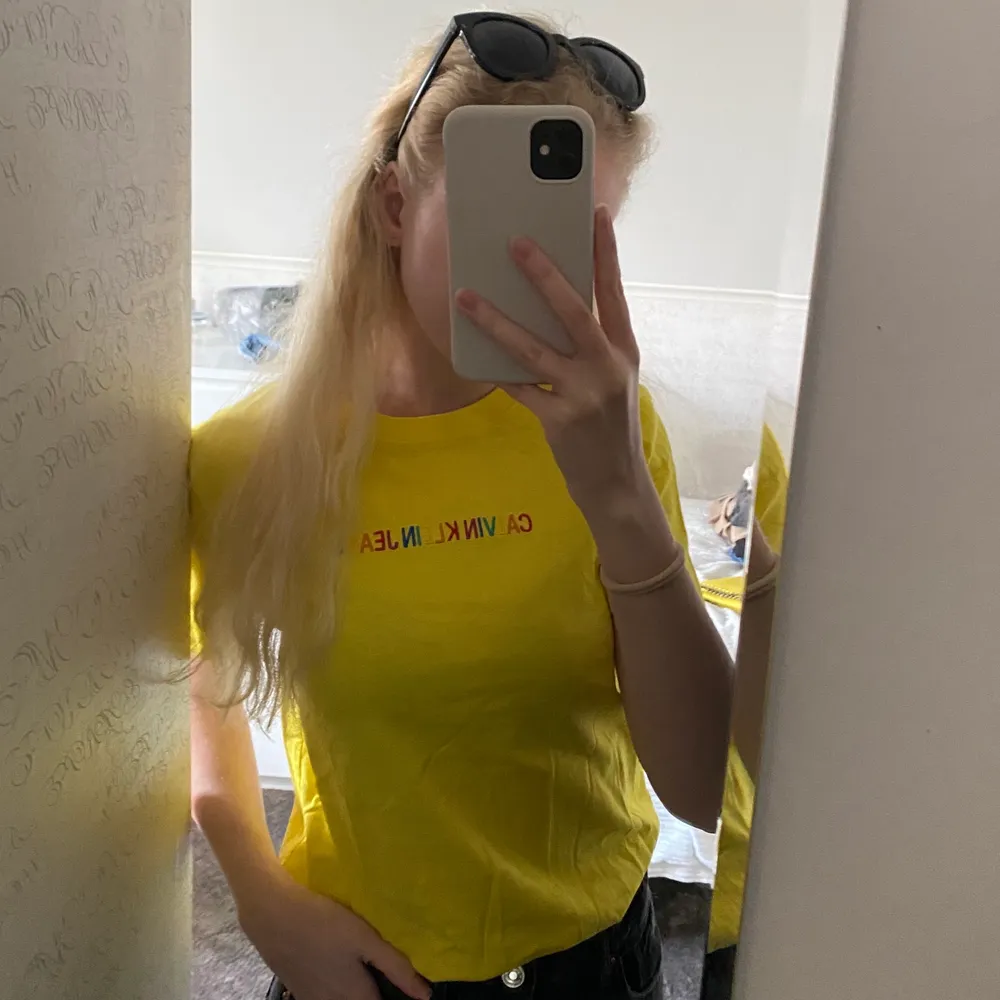 En superfin gul Calvin Klein T-shirt, med regnbågsfärgat broderat märke på! Använd 2 gånger, i nyskick, inga defekter ✨ fler bilder finns. T-shirts.