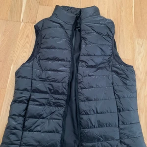 Helt ny svart väst - Säljer en helt ny glansig väst med lappar kvar pga att den inte passade. Storlek 38 men är som en XS/S och passar nog de under 170 cm bättre. 