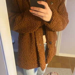 Brun teddyjacka  - Brun supermysig teddyjacka med prislappen kvar! Aldrig använd, superfin som höstjacka. Köpte i en liten butik på västkusten så platt vart den kommer ifrån!