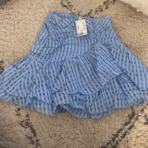 Oanvänd minikjol - Jättefin kjol från h&m i storlek 36. Aldrig använd och prislappen sitter kvar. Dragkedja där bak samt volang mini kjol. Helt i nyskick. 