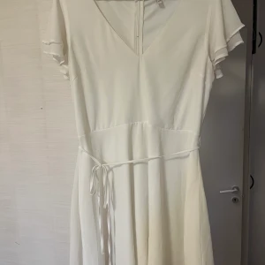 Vit klänning Nelly  - Säljer min fina studentklänning ifrån Nelly. Endast använd en gång🥰 i fint skick, inga fläckar.                                     Storlek 44
