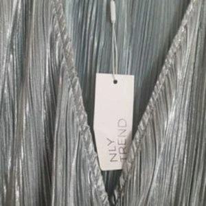 Silvrig klänning - Silvrig blank blågrå XL/42 180kr  Cm ca Längd 94  Bröst 105 Midja 93 (ej utstretchad) Höft 110  Hämtas i Sundbyberg eller skicka med postnord skicka lätt 57 kr