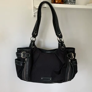 Svart axelväska - Svart väska med silverdetaljer från Gerry Weber i mellanstorlek, perfekt som skolväska! Bra skick men lite slitningar på banden 👜