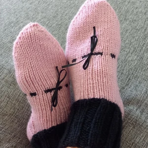 Nya rosa/svarta stickade sockor - Nya söta sockor för frusna fötter. Stickade i garn som inte är stickigt. På ovansidan av foten sitter en liten rosett i sidenband som inte skaver när du använder sockarna i vinterkängorna. Kan tvättas i 40 grader.
