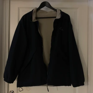Jacka från Kappa  - Otrolig jacka från kappa! Den går att ha åt båda hållen och är som en fleece på ena sidan! Älskar denna, köpt second hand men är i väldigt fint skick! Det enda jag sett är att tyget åkt på vid insidan av flärpen på ena fickan, inget som syns eller påverka
