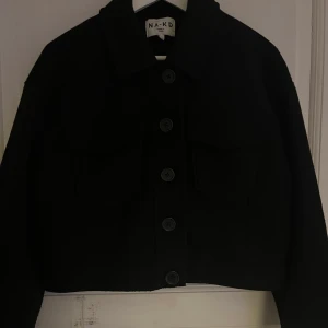 Svart kappa - Säljer denna kappa/skjortjacka från NA-KD. Köpt här på Plick och i väldigt fint skick. Den kommer inte till användning därför säljer jag den